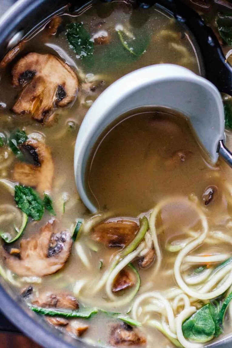 A ladle scooping Vegan Ramen Soup w/ Zucchini Noodles!