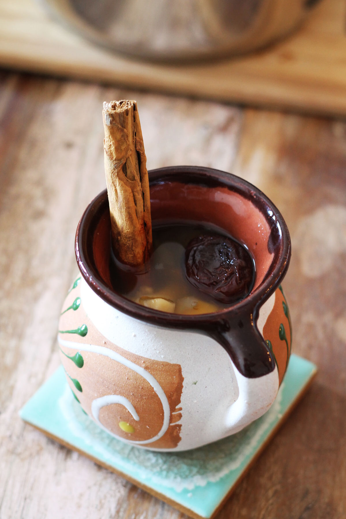 Mexican Ponche in a cozy cup with cinnamon stick.
