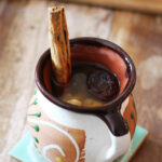 Mexican Ponche in a cozy cup with cinnamon stick.