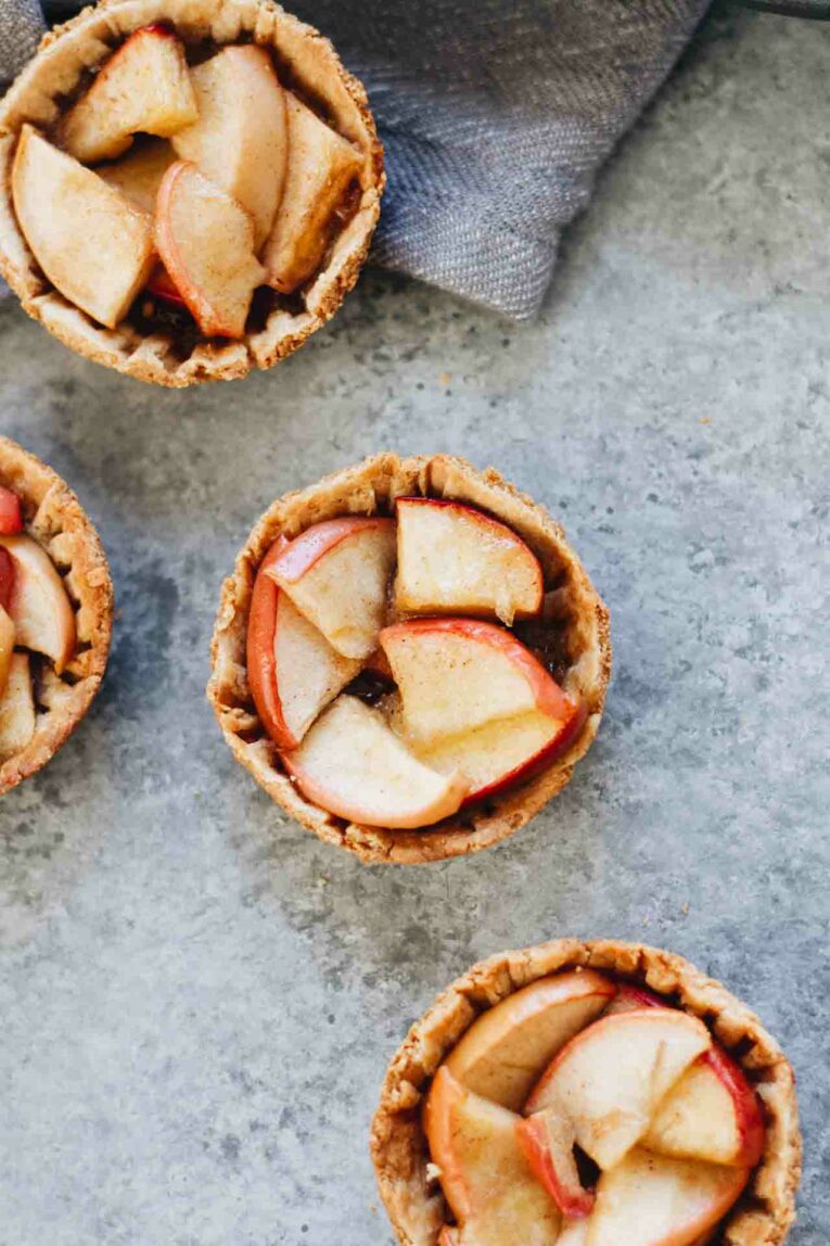 Mini Apple Pies on a Gray Background with a Gray Napkin