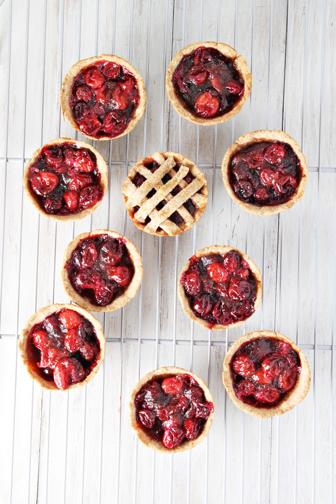 Top shot of mini cranberry pies on a cooling rack.