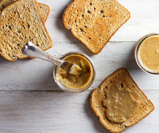 Homemade Kaya Coconut Egg Jam in a glass jar with a knife and toast at the side