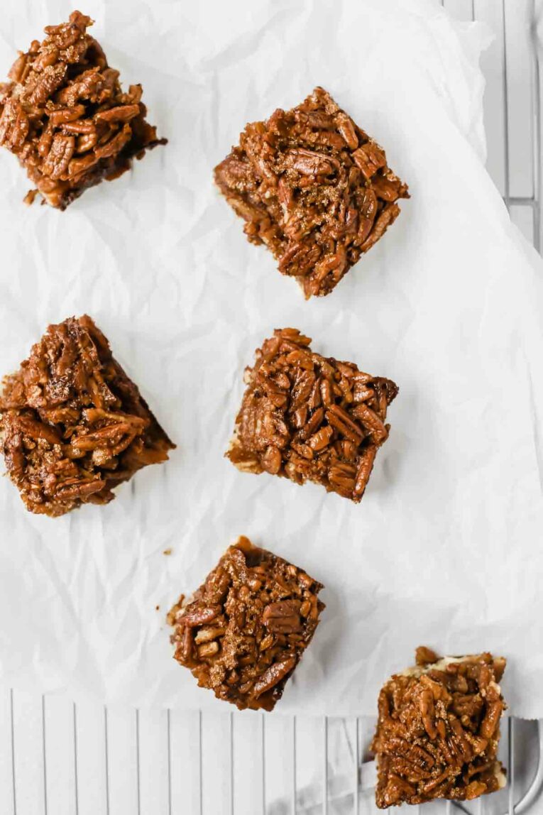 Pecan Pie Bars on a White Parchment Paper on a Cooling Rack