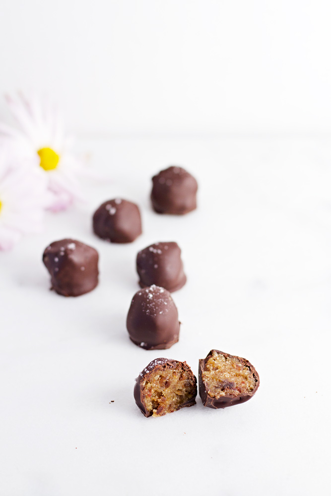 Healthy Salted Caramel Truffles on a white surface with one cut in half