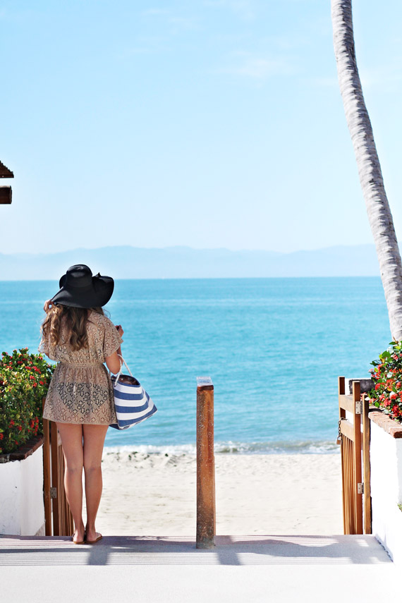 girl standing on steps in front of a beach