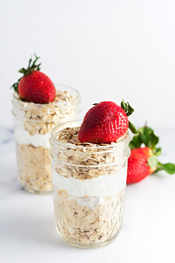 Strawberries & Cream Overnight Oats served in two mason jars topped with fresh strawberries