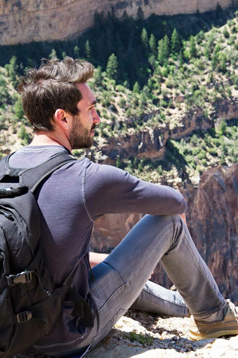 guy sitting overlooking Grand Canyon