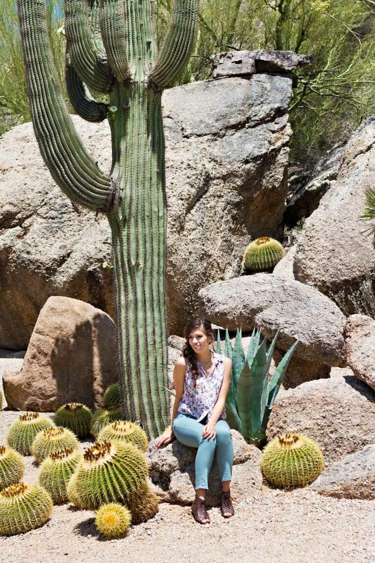 girl sitting on rock in front of Gian cactus