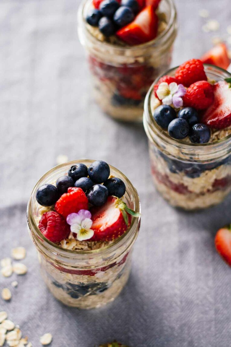 Triple Berry Overnight Oats served in 3 mason jars.