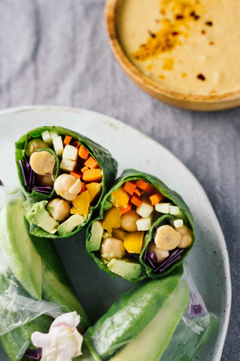 close up of Vegan Spring Rolls on a white plate w/ Spicy Turmeric Coconut Sauce on the side! 