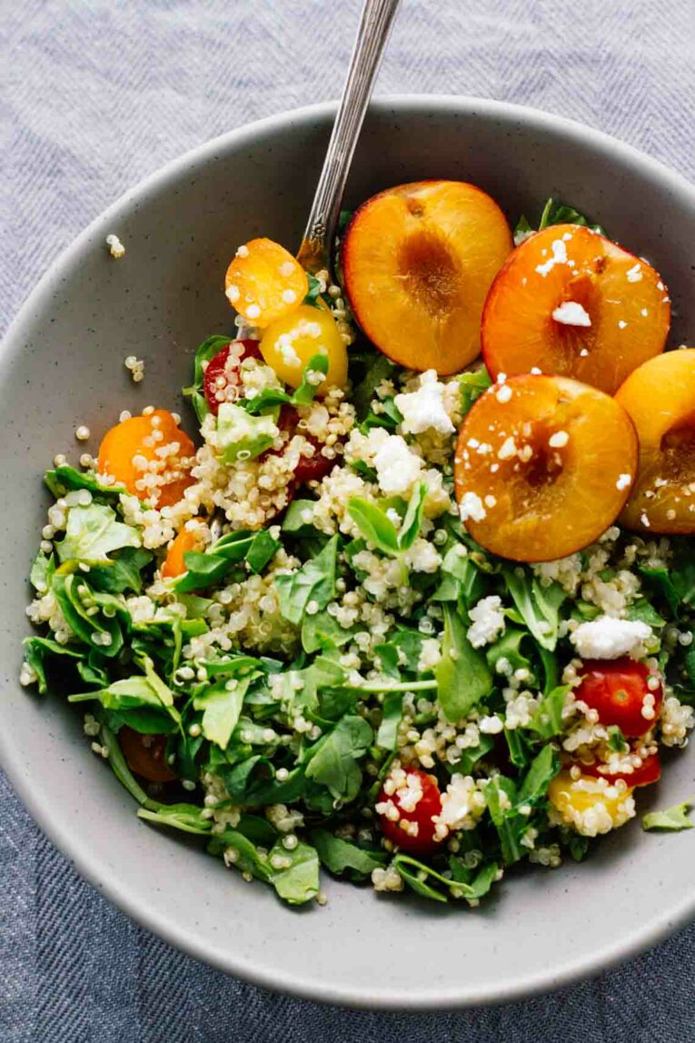 Cherry Plum & Goat Cheese Summer Salad in a grey bowl with a fork.