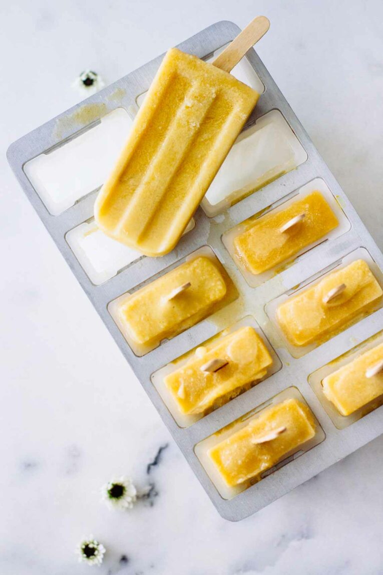 Coconut Peach Turmeric Popsicles in a popsicle tray