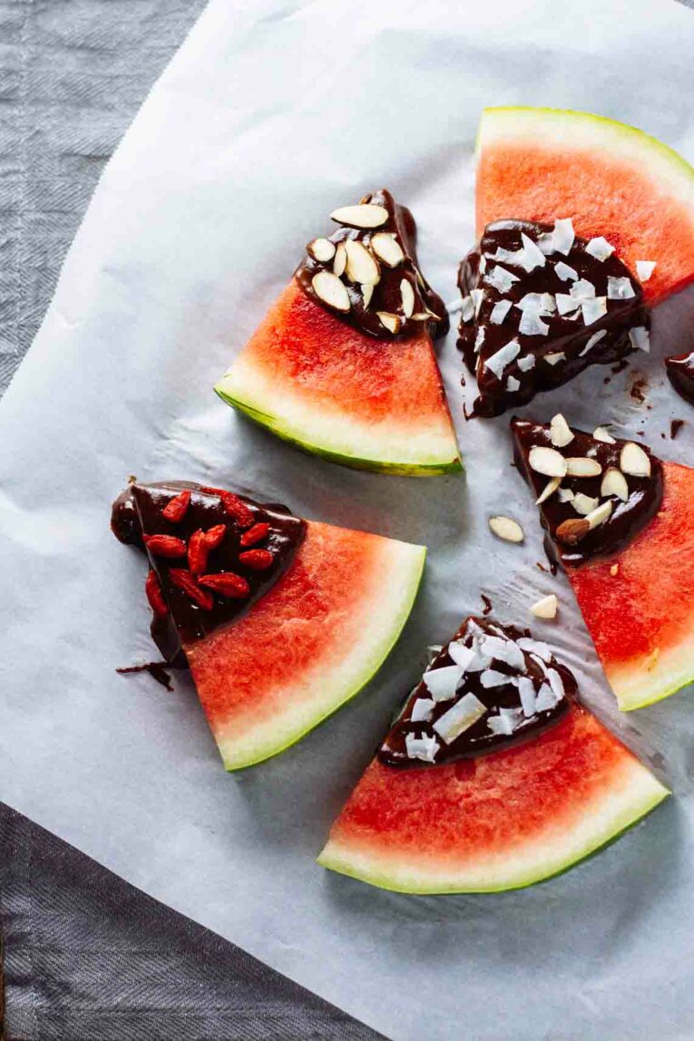 Tahini-Chocolate Dipped Watermelon Wedges arranged on parchment paper