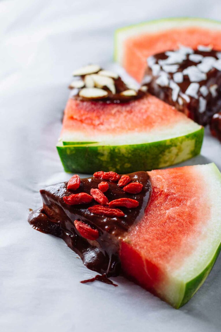Tahini-Chocolate Dipped Watermelon Wedges arranged on a white background