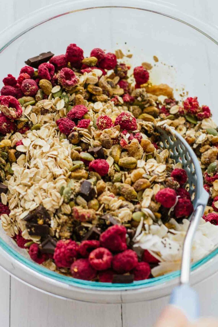 Homemade Chocolate Raspberry Muesli! Vegetarian, gluten-free, refined sugar free. An easy, quick, and healthy breakfast! Make this stuff in about 10 minutes and keep it in your pantry for 2 or more weeks! #Jaroflemons #Muesli #healthybreakfast An overhead shot of homemade muesli with raspberries, pistachios and chocolate chips
