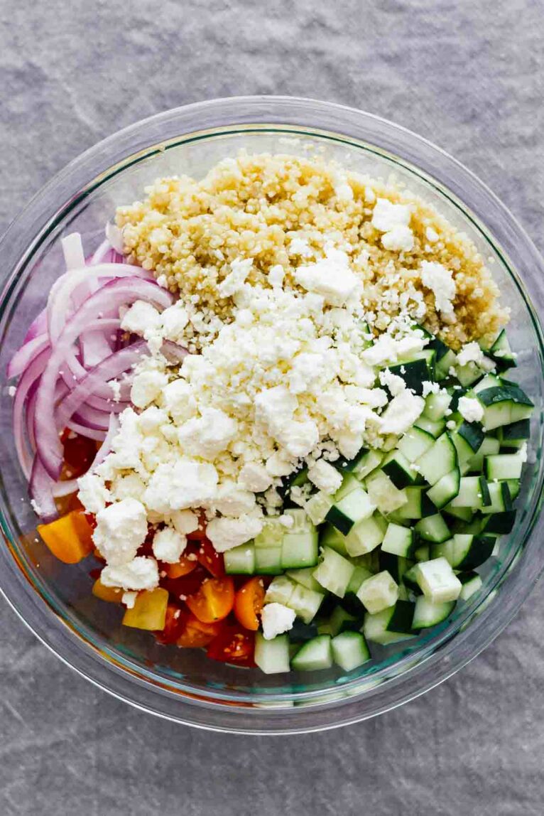 Overhead shot of ingredients for Mediterranean Salad Bowls w/ Lebanese BBQ Meatballs in a glass bowl. 