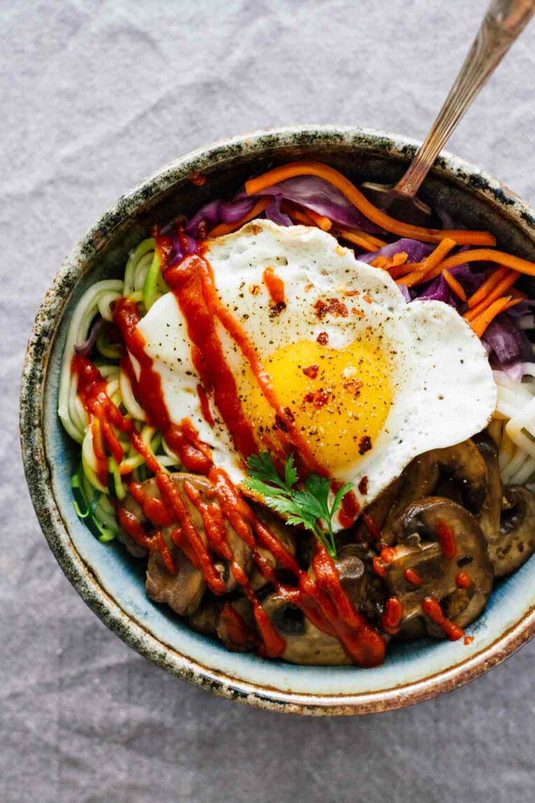 Vegetarian Spicy Korean Bibimbap Bowl on a grey background 