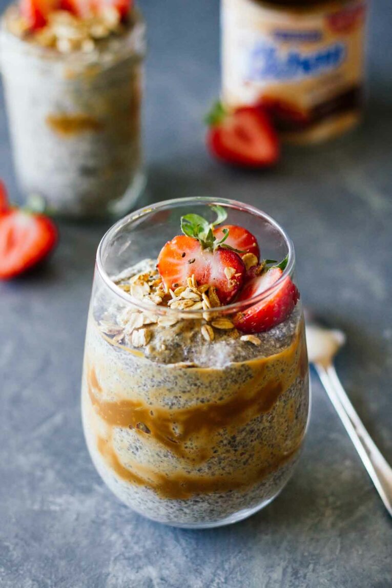 Dulce De Leche Chia Seed Parfait! Such a delicious and healthy dessert or breakfast treat that's creamy, sweet and utterly irresistible. Made with layers of chia pudding, caramel, and juicy strawberries. #Jaroflemons #chia #healthydessert #parfait Dulce De Leche Chia Seed Parfait in a glass topped with fresh strawberries
