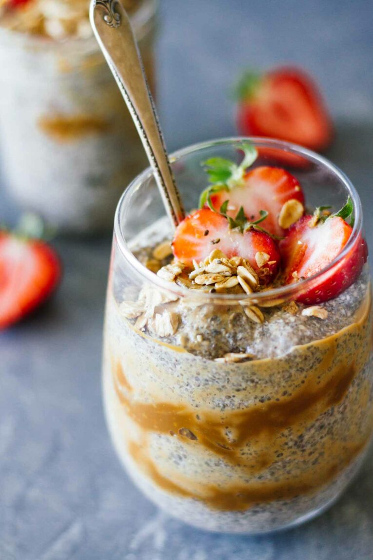 Dulce De Leche Chia Seed Parfait! Such a delicious and healthy dessert or breakfast treat that's creamy, sweet and utterly irresistible. Made with layers of chia pudding, caramel, and juicy strawberries. #Jaroflemons #chia #healthydessert #parfait A close up of Dulce De Leche Chia Seed Parfait with a spoon
