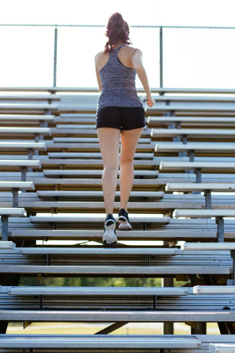 girl running up bleachers