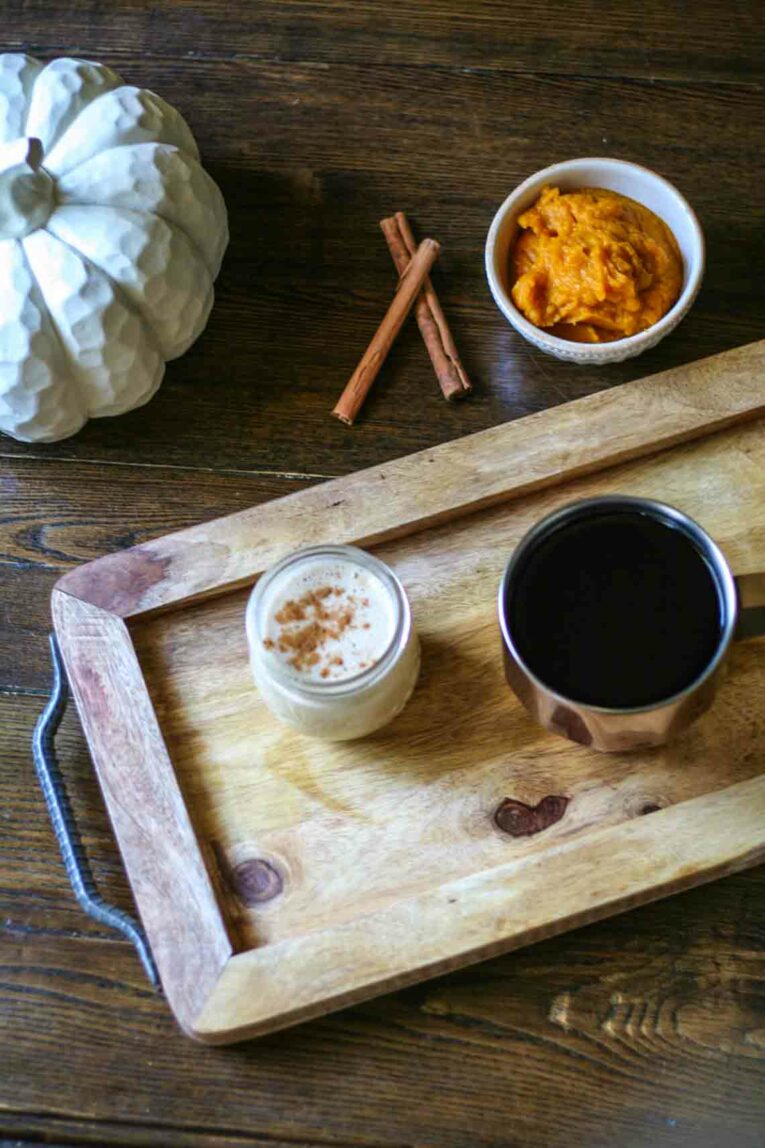 overhead shot of Paleo Pumpkin Coffee Creamer in a glass jar next to a cup of coffee
