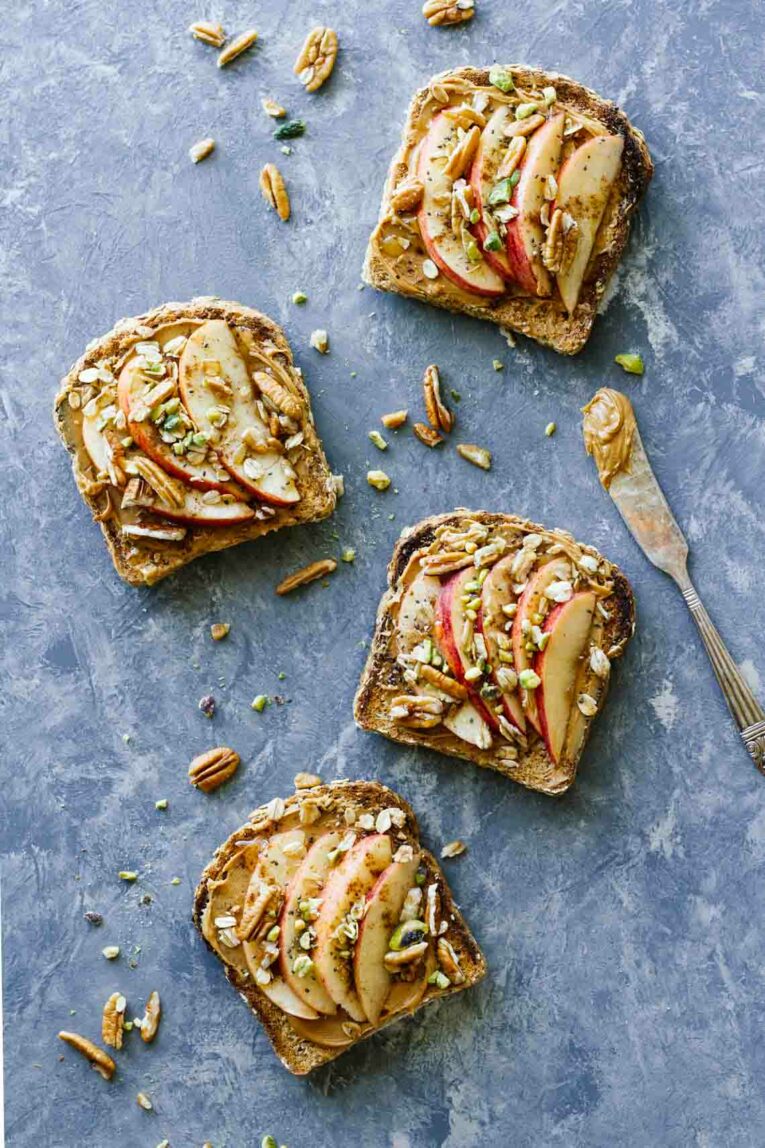 Several slices of Apple Cinnamon Peanut Butter Breakfast Toast on a countertop next to knife with peanut butter.