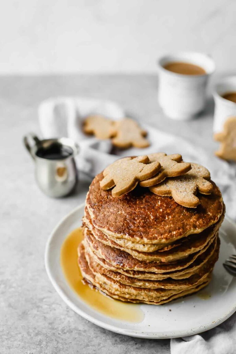 Stack of Sweet, wholesome, Healthy Gingerbread Oatmeal Pancakes with gingerbread cookies on top.