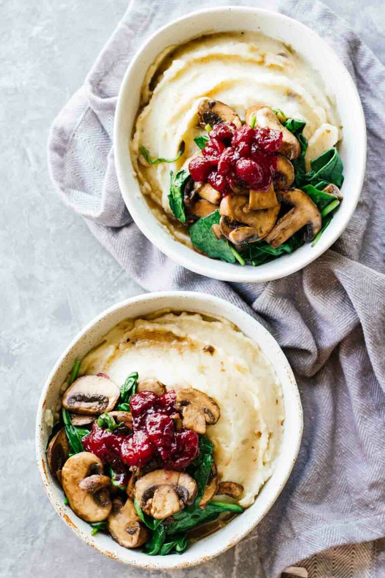 Slow Cooker Mashed Potatoes topped with Cranberry Mushroom Sauce and spinach.