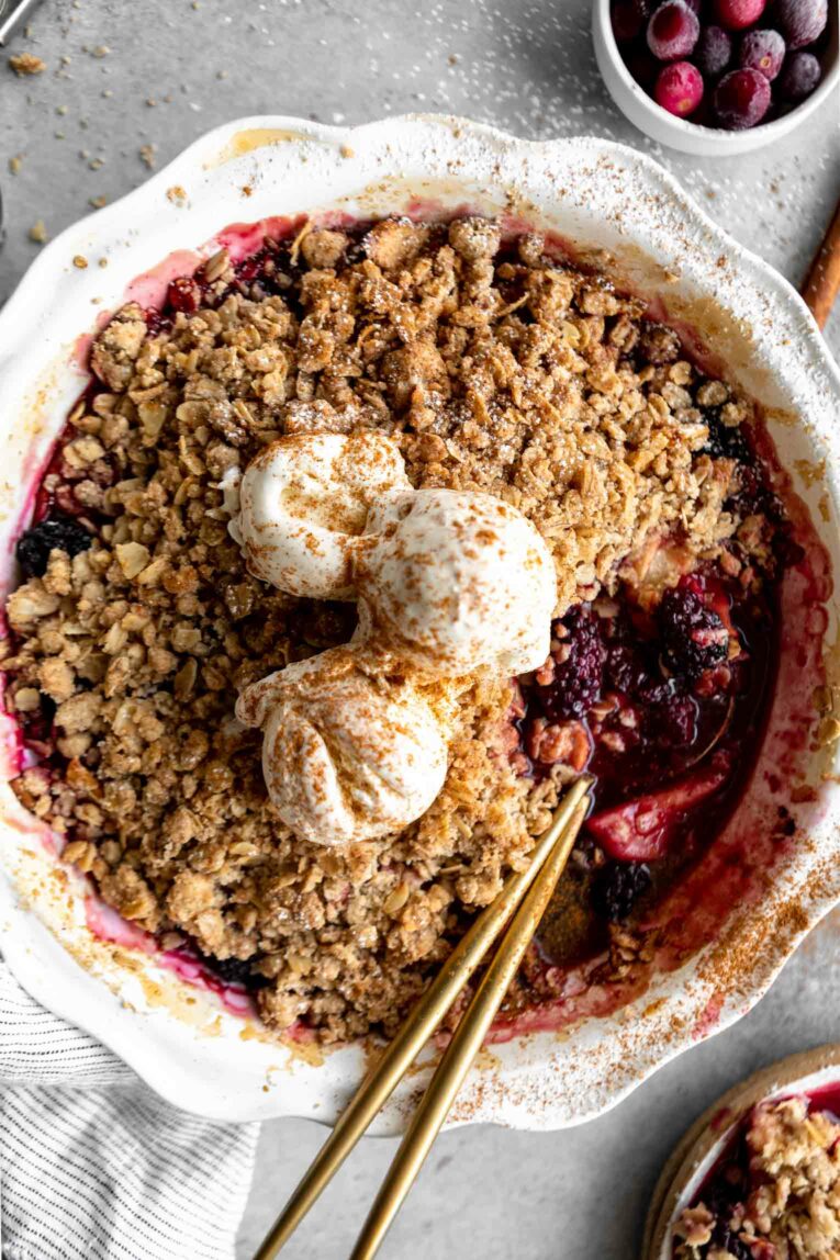 Cranberry Ginger Crumble Fruit Bake Topped with Yogurt in a Gray Bowl with a Spoon