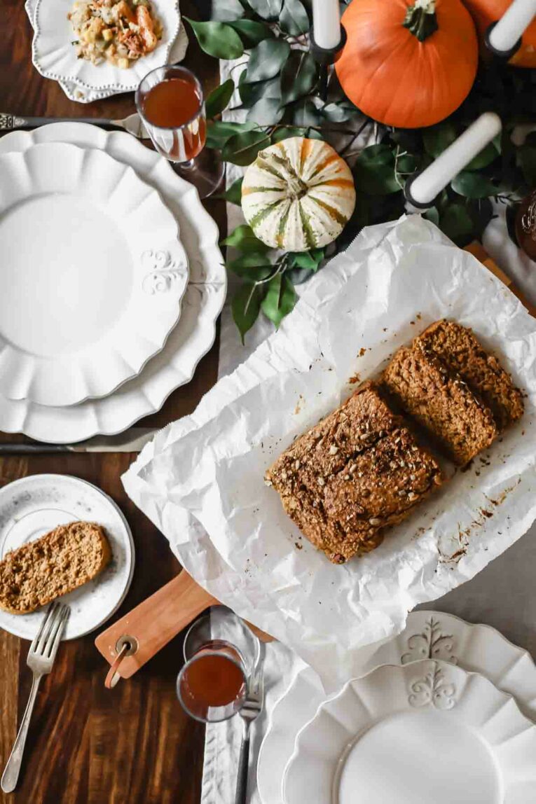 Overhead shot of baked bread sitting on a table set for Thanksgiving.