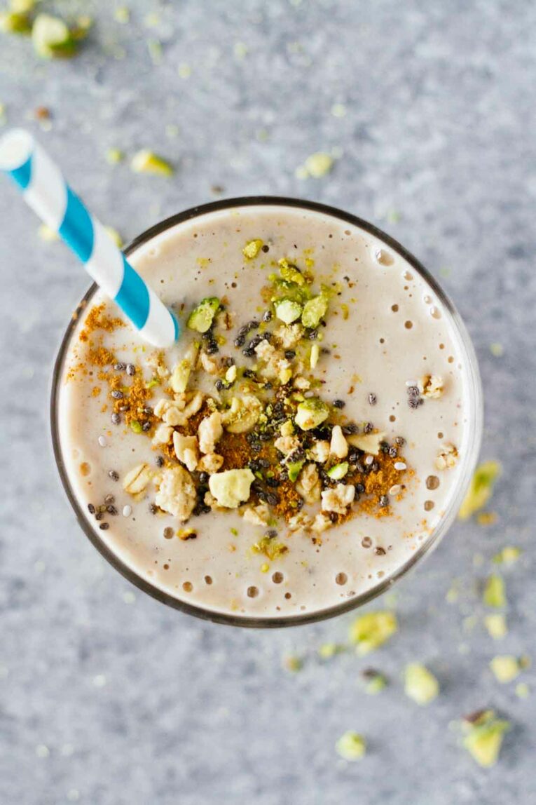 An overhead shot of a Banana Cashew Butter Chia Seed Smoothie topped with nuts