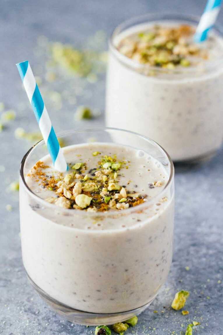 Banana Cashew Butter Chia Seed Smoothies in glass cups topped with granola.