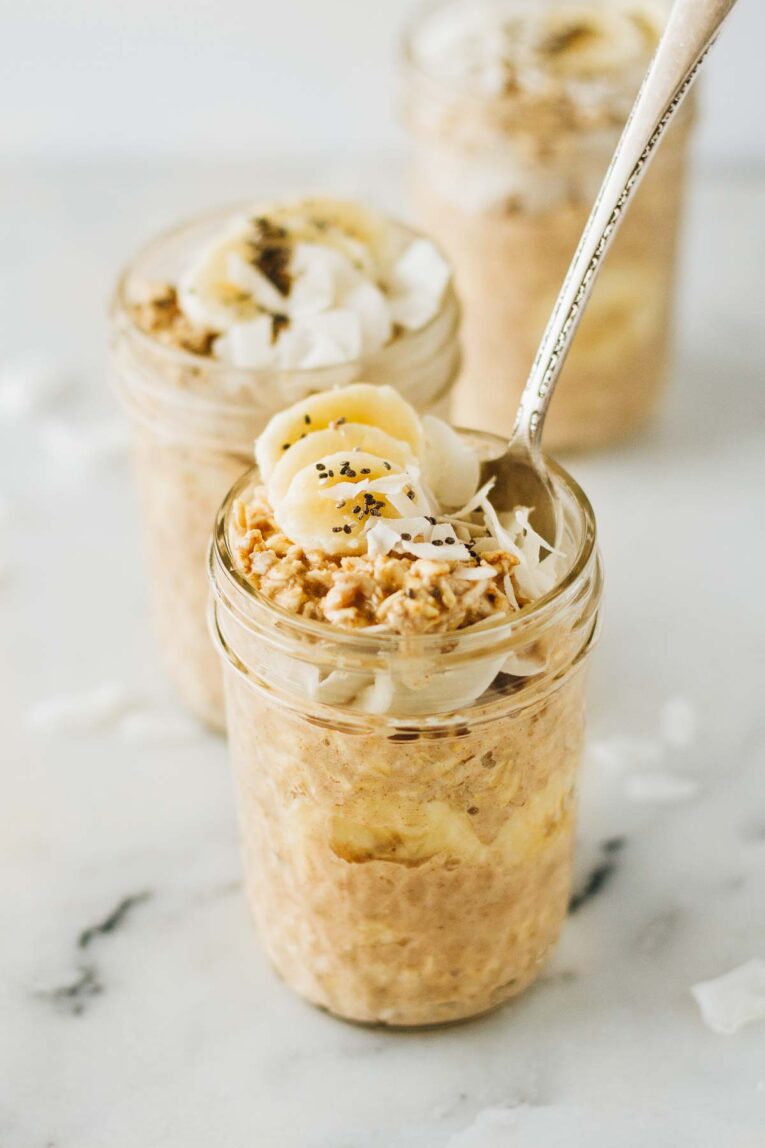 Mason jar with banana overnight oats on a marble table
