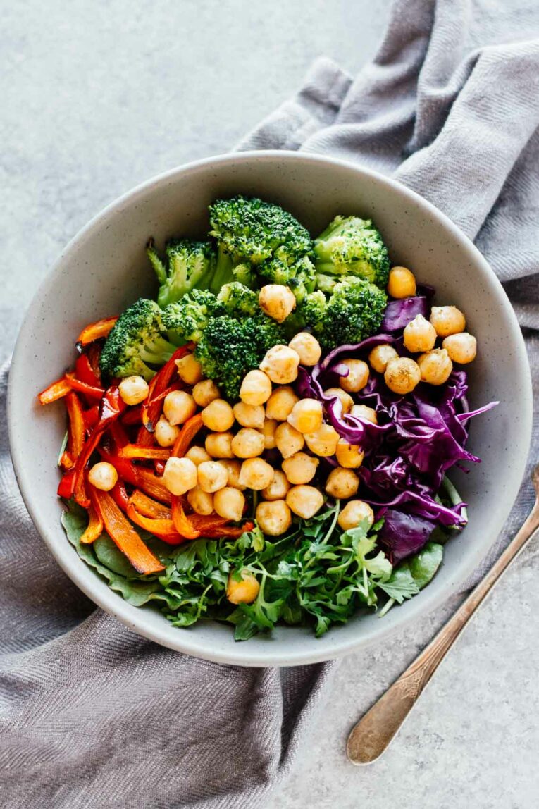 overhead shot of Broccoli & Chickpea Rainbow Power Bowls in a grey bowl on a grey dishcloth
