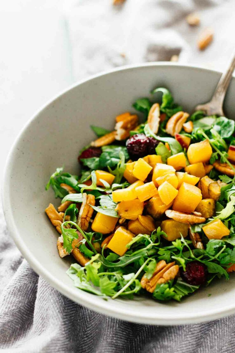 Golden Beet Pecan Detox Salad in a white bowl with a fork
