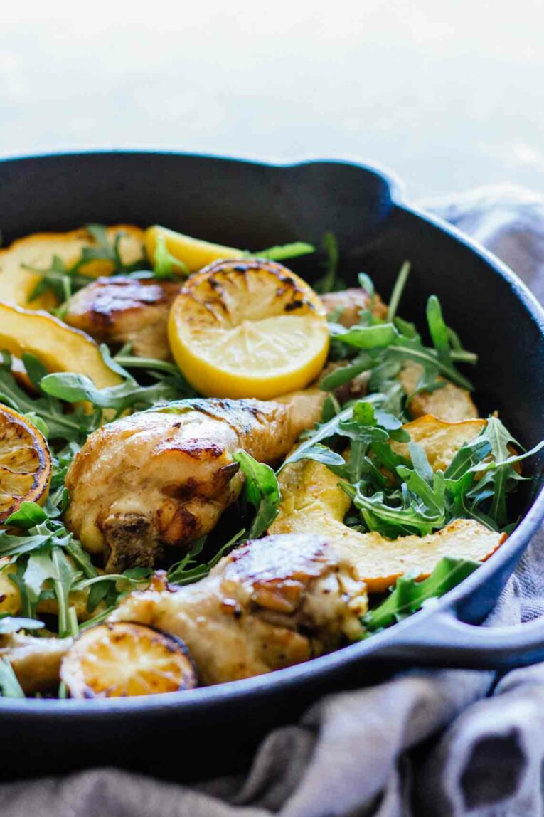 side view of  Chicken, Acorn Squash, and Arugula in a cast iron skillet