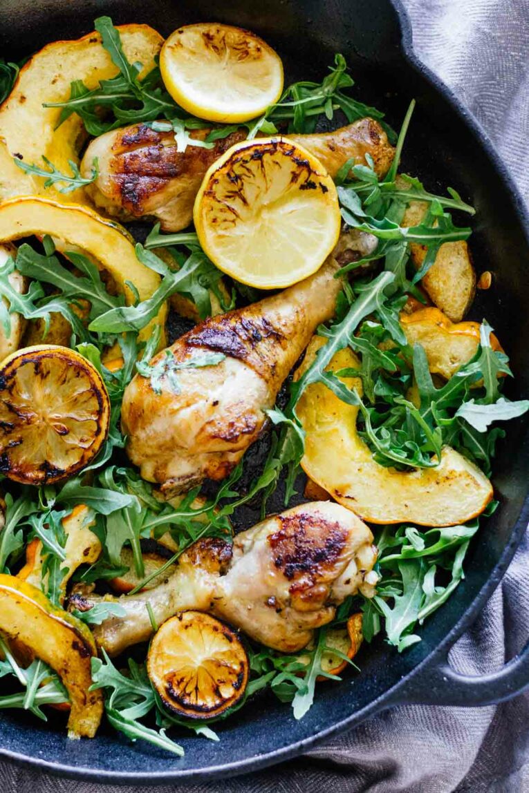Black Skillet with Chicken Thighs, Acorn Squash Slices, Arugula, and Lemon Slices!