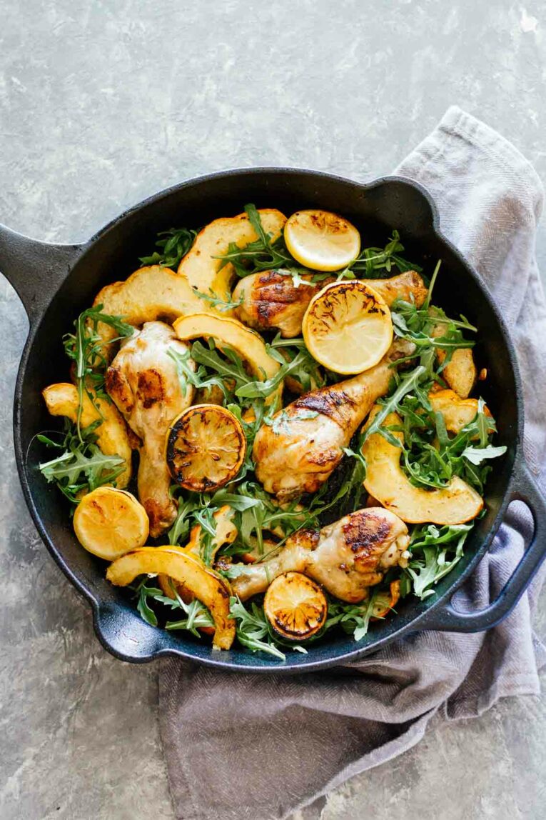 overhead view of  Chicken, Acorn Squash, and Arugula in a cast iron skillet