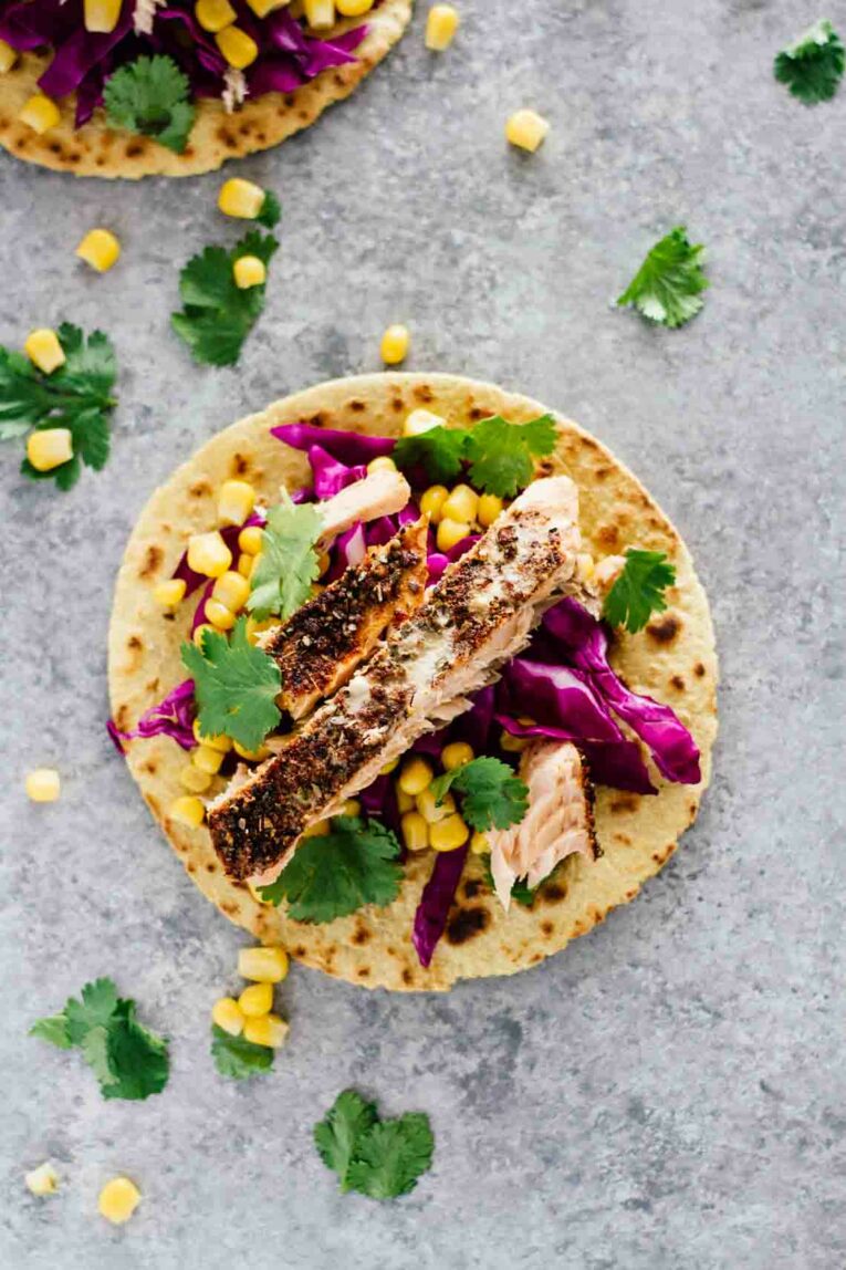 Overhead shot of 30-Minute Blackened Salmon Tacos on a blue surface