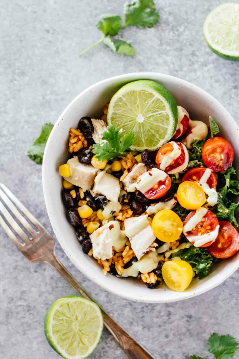 A topshot photo of a bowl of chicken in a southwest burrito bowl.