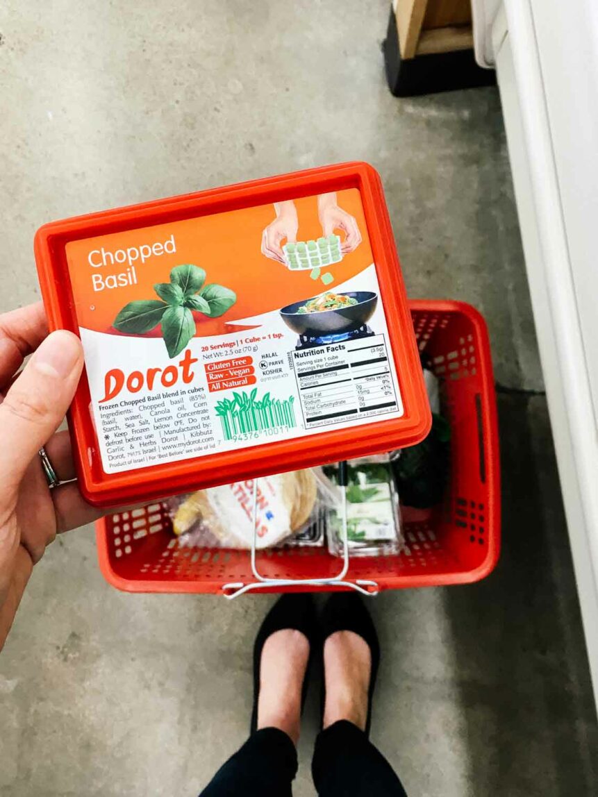 Someone holding a packet of Dorot frozen basil cubes