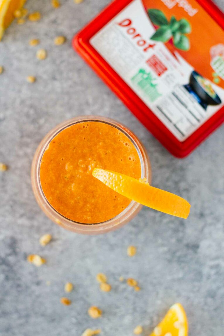 An overhead shot of an orange carrot smoothie in a glass