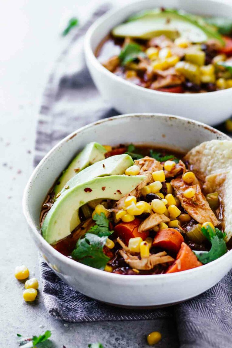 Slow Cooker Skinny Chicken Tortilla Soup served in two white bowls on a blue dishcloth
