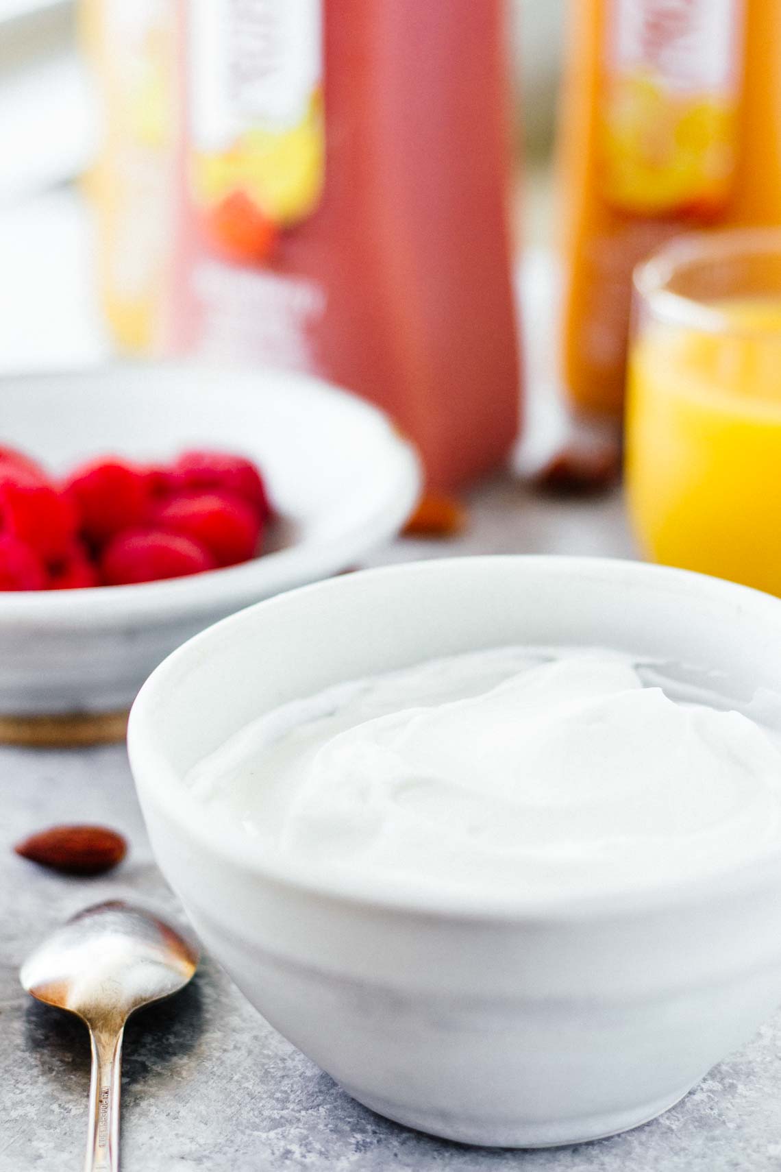 picture of yogurt in a white bowl next to a spoon