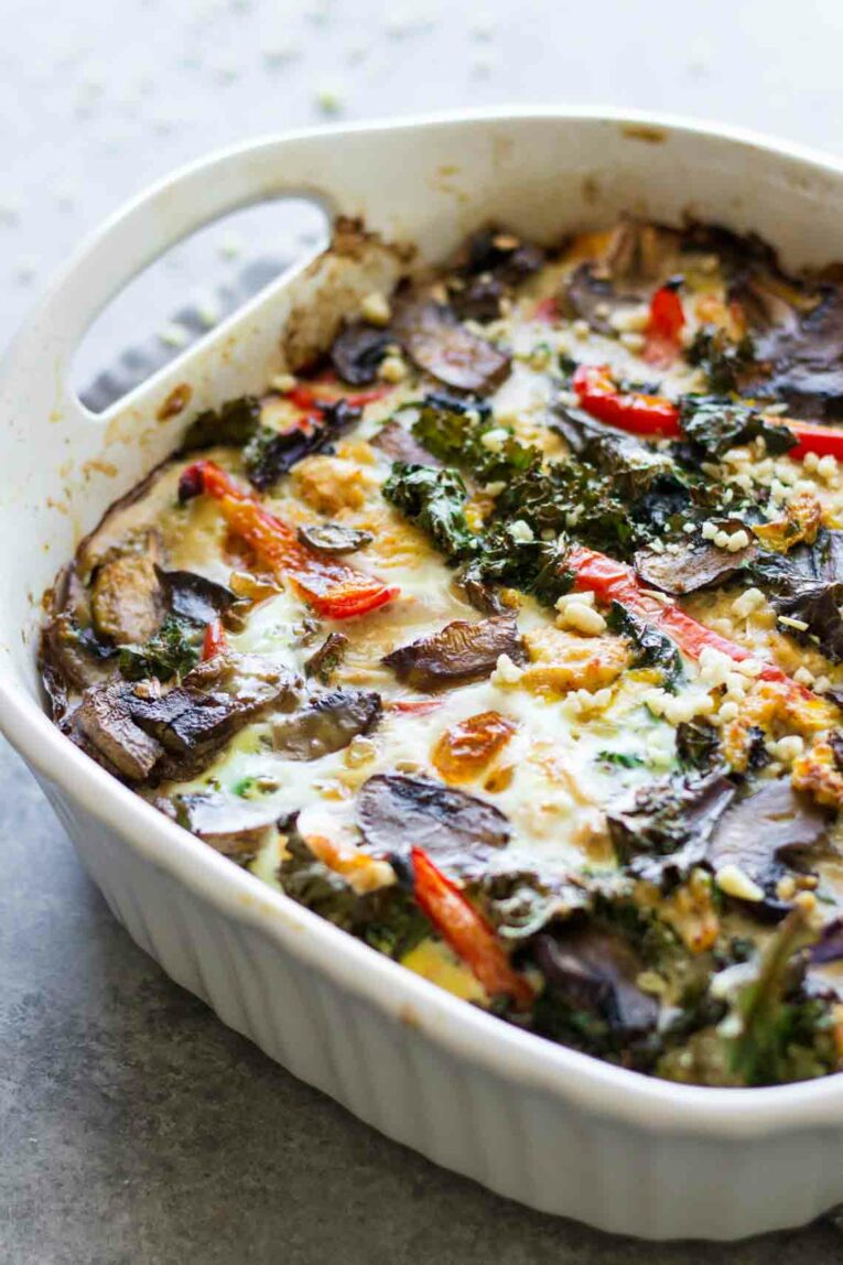 A close up of a breakfast casserole with peppers and mushrooms