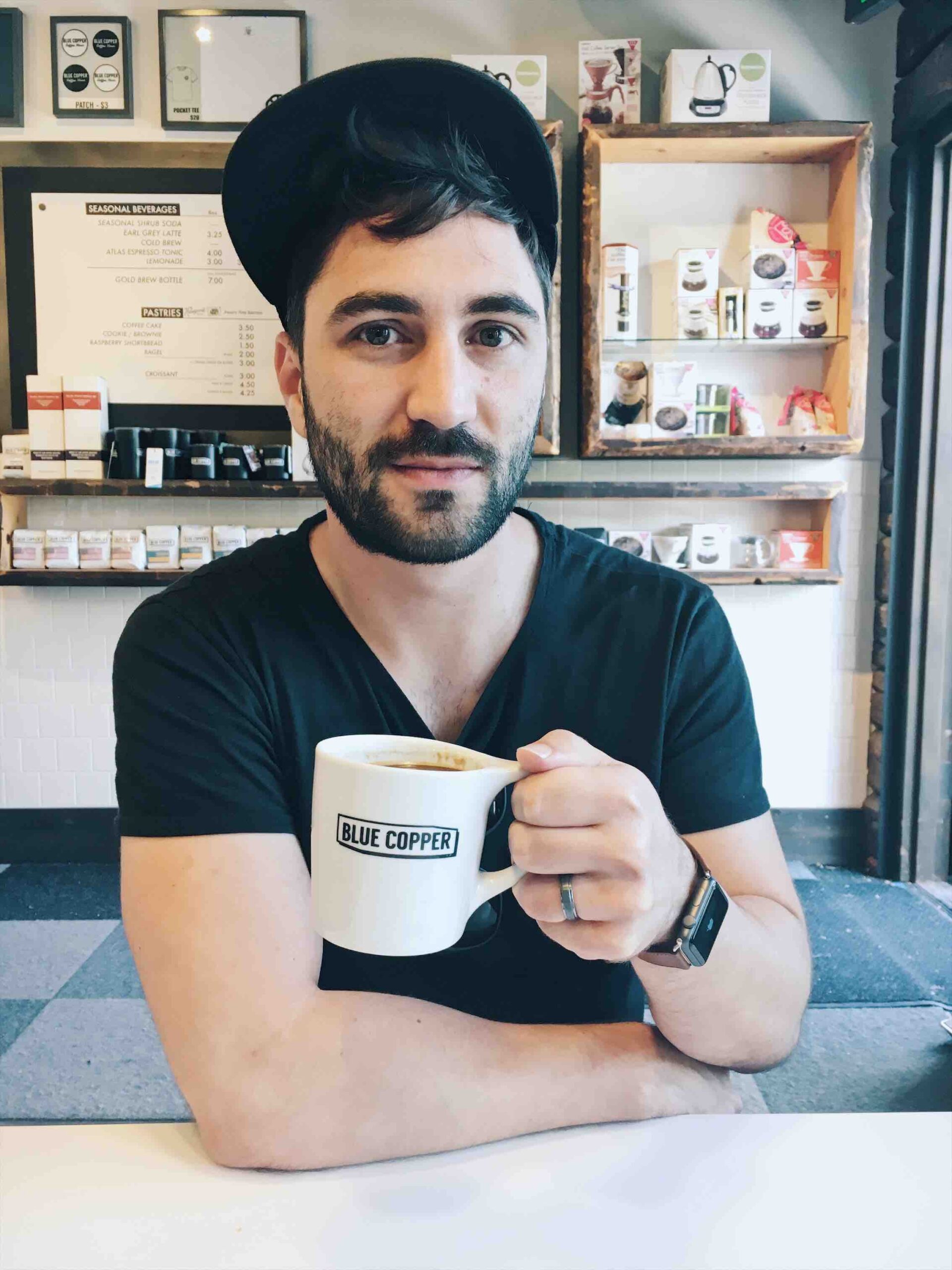 Picture of guy holding a coffee mug inside a coffee house