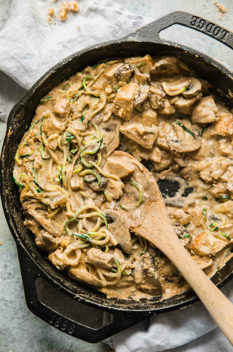 Paleo chicken mushroom casserole skillet with wooden spoon top shot