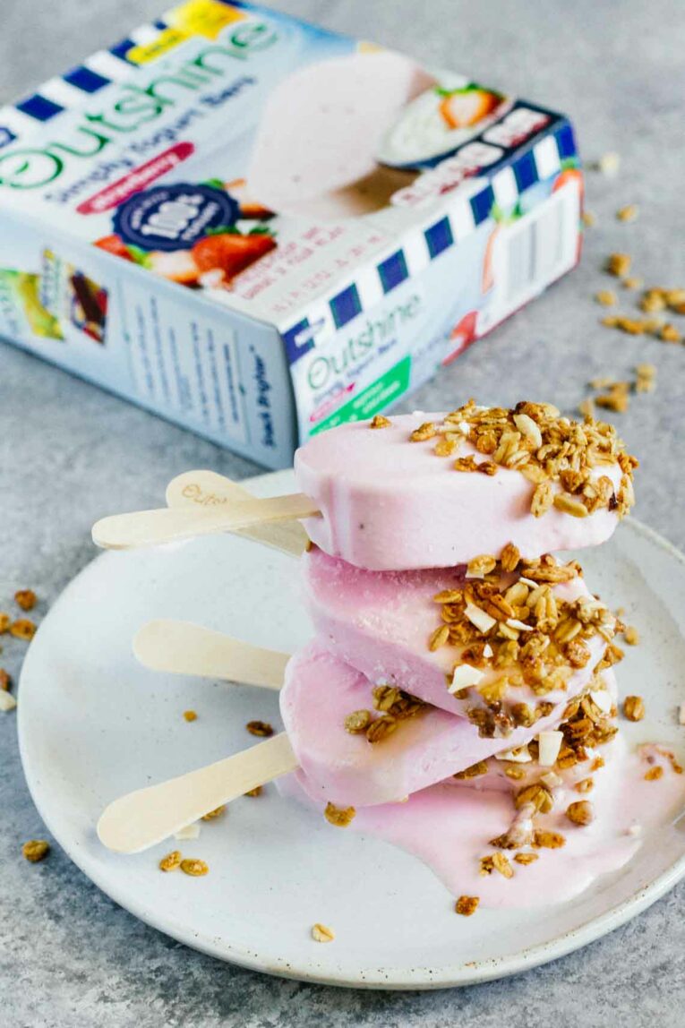 A pile of Strawberry Frozen Yogurt Bars on a plate with granola