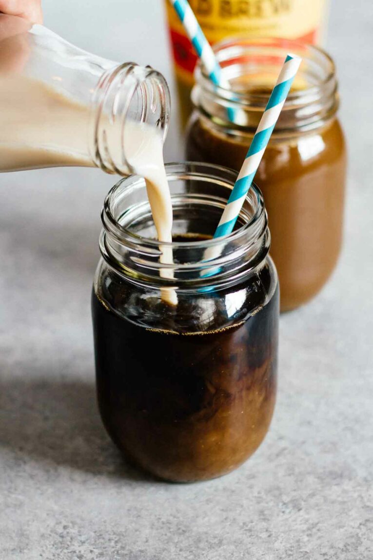 The most delicious Vanilla Coconut Cold Brew Coffee made with simple ingredients and taste better than your coffee shop favorite. You won't believe how easy it is to make cold brew at home, perfect for summer! #coldbrewcoffee #coldcoffee #coffeedrink Milk pouring into cold brew coffee
