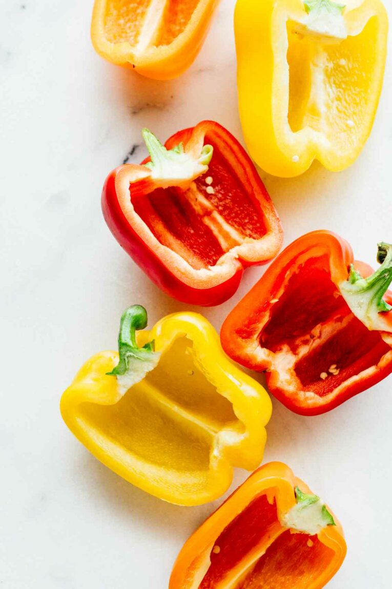 Spicy Southwest Whole30 Stuffed Peppers! These are SO easy to make and perfect for meal prep. Make them in 30 minutes! Also Paleo friendly and gluten free! #jaroflemons #whole30 #stuffedpeppers Sweet peppers cut in half sitting on a white surface